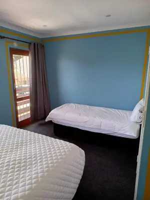 a bedroom with two beds and a blue wall at Capetown Adilo Villa 2 in Cape Town