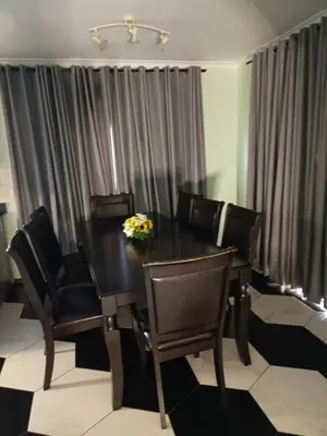 a dining room table with chairs and a black table at Capetown Adilo Villa 2 in Cape Town