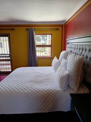 a bedroom with a large white bed with pillows at Capetown Adilo Villa 2 in Cape Town
