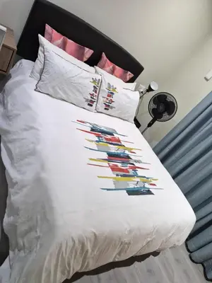 a bed with a white comforter with colorful pillows at Secure Modern stay at 41 on Kennington in Parklands