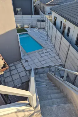 a stairway leading to a swimming pool in a house at Secure Modern stay at 41 on Kennington in Parklands