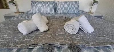 a bed with white towels and pillows on it at Cozy Quarters Self-Catering Accommodation in Bellville