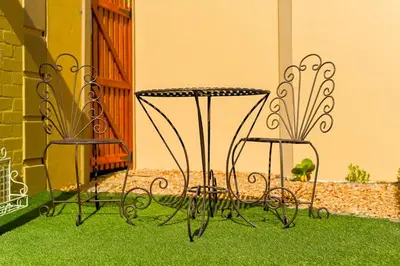 two chairs and a table sitting on the grass at Velvet & Bloom Cottage in Durbanville in Oakdale