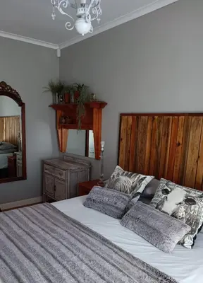 a bedroom with a large bed with a wooden headboard at Anna's House of Arts in Strand