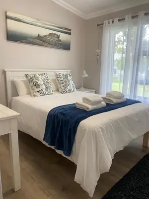 a bedroom with a white bed with towels on it at Living Lite in Kleinmond