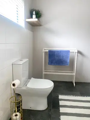 a bathroom with a white toilet in a room at Living Lite in Kleinmond