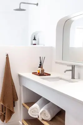 a bathroom with a sink and a mirror and towels at The Oak Cottage in Wellington