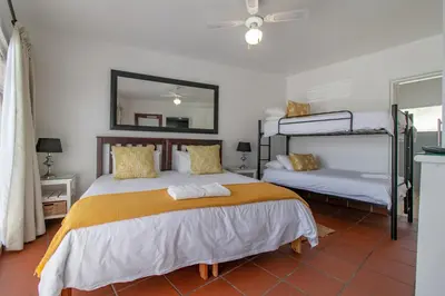 a bedroom with two bunk beds and a mirror at TwentyFour 17 Inn in Hermanus