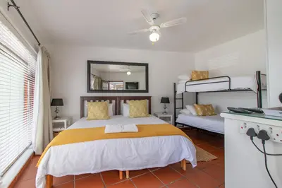 a bedroom with a bed and two bunk beds at TwentyFour 17 Inn in Hermanus