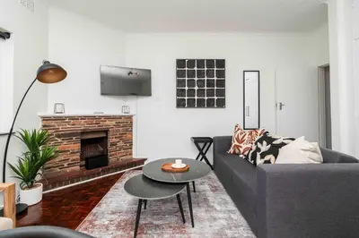 a living room with a couch and a fireplace at First floor Claremont Studio apartment in Cape Town
