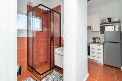 a bathroom with a shower with orange tile at First floor Claremont Studio apartment in Cape Town