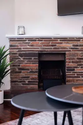 a fireplace with a table in front of it at First floor Claremont Studio apartment in Cape Town