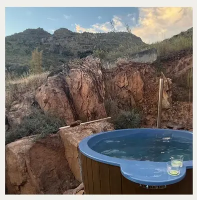 a hot tub with a view of a mountain at Kerala Cottage - farm charm inspired self-catering