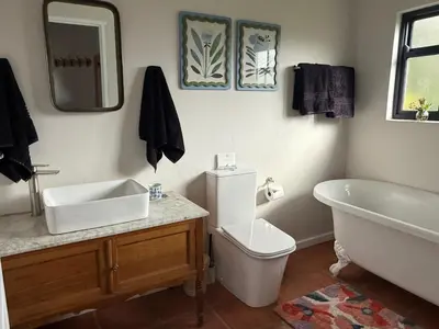 a bathroom with a sink and a tub and a toilet at Kerala Cottage - farm charm inspired self-catering
