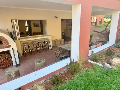 a patio with a table and chairs and a fireplace at Kerala Cottage - farm charm inspired self-catering
