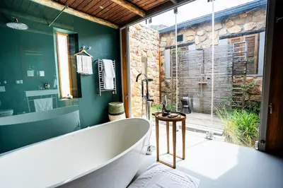 a bathroom with a large tub and a large window at Drakenskloof - Exclusive-Use Mountain Homestead