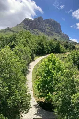 a dirt road with a mountain in the background at Swan Cottage in Kylemore