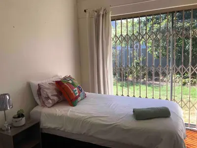 a bed with pillows and a window in a bedroom at Newly renovated Stellies 2 Bed apt in heart of Stellies! in Stellenbosch