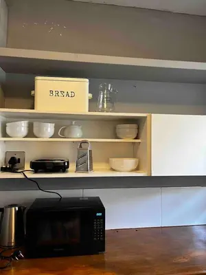 a microwave oven sitting on top of a shelf at Newly renovated Stellies 2 Bed apt in heart of Stellies! in Stellenbosch
