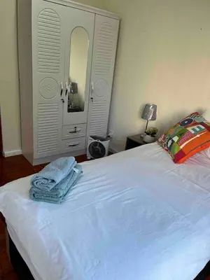 a bedroom with a white bed with towels on it at Newly renovated Stellies 2 Bed apt in heart of Stellies! in Stellenbosch