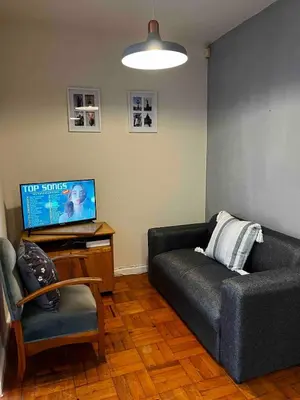 a living room with a couch and a tv at Newly renovated Stellies 2 Bed apt in heart of Stellies! in Stellenbosch