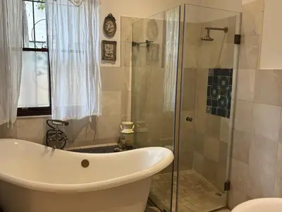 a bathroom with a tub and a glass shower at Heldeberg 6 in Stellenbosch