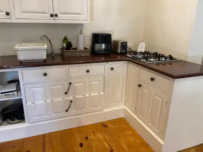 a kitchen with white cabinets and a counter top at Heldeberg 6 in Stellenbosch
