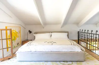 a bedroom with a large bed in a attic at Authentic and Charming French-inspired Cottage in Franschhoek
