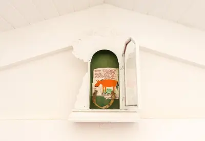a bottle of wine in a white shelf in a room at Authentic and Charming French-inspired Cottage in Franschhoek