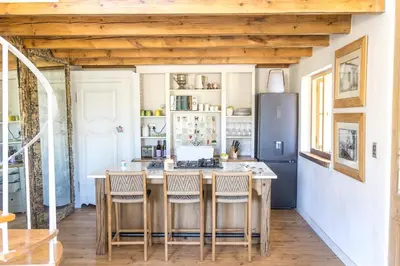 a kitchen with a table and chairs and a refrigerator at Authentic and Charming French-inspired Cottage in Franschhoek