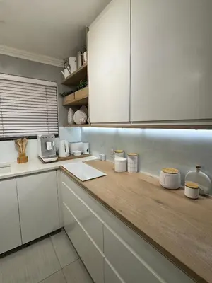 a kitchen with white cabinets and a wooden counter top at 3at33 CT in Cape Town