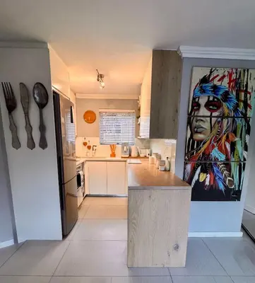 a kitchen with a large painting on the wall at 3at33 CT in Cape Town