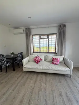 a living room with a white couch with pink pillows at Plattekloof Mountain view in Plattekloof