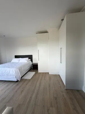 a bedroom with white walls and a bed and wooden floors at Plattekloof Mountain view in Plattekloof