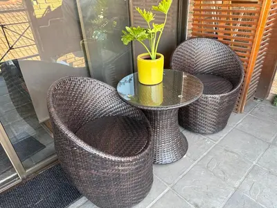 three wicker chairs and a table with a potted plant at Balcony mountain views free fibre-wifi aircon and parking in Wellington