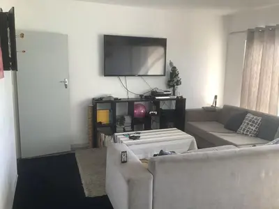 a living room with two couches and a flat screen tv at Central and close to the beach in Cape Town