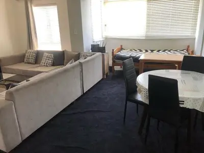 a living room with a couch and a table and chairs at Central and close to the beach in Cape Town