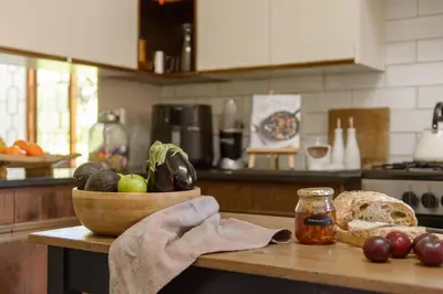 a kitchen counter with a bowl of vegetables and bread at Am Flus- at the river in Stellenbosch