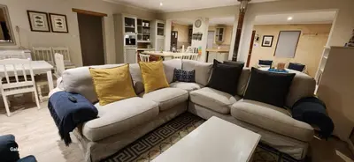 a living room with a white couch with yellow pillows at Sea front holiday home in Bettyʼs Bay