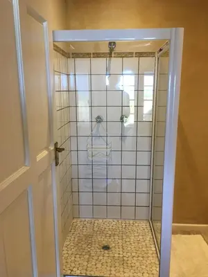 a shower with a glass door in a bathroom at Sea front holiday home in Bettyʼs Bay