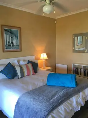 a bedroom with a large white bed in a room at Sea front holiday home in Bettyʼs Bay