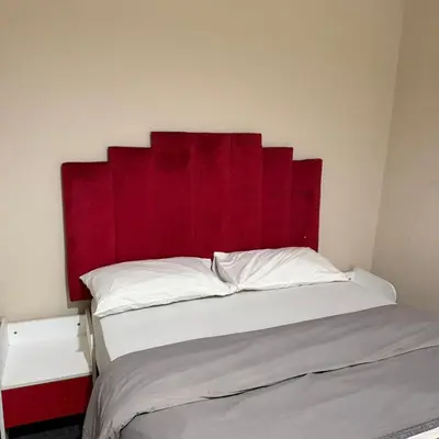 a bed with a red headboard in a room at Home of peace self catering accommodations
