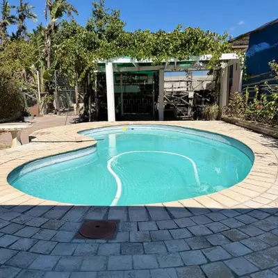 a small swimming pool in a yard with a building at Home of peace self catering accommodations