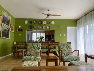 a living room with green walls and a table and chairs at Salty Leaves in Hermanus