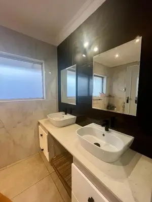 a bathroom with two sinks and a mirror at Paarl View House in Paarl