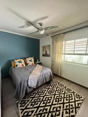 a bedroom with a bed and a ceiling fan at Paarl View House in Paarl
