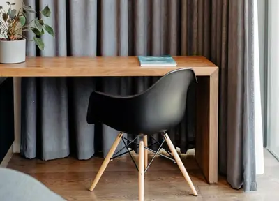 a black chair sitting in front of a wooden desk at Amour in Pniel