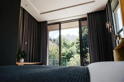 a bedroom with a bed and a large window at Amour in Pniel