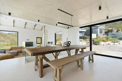 a large dining room with a wooden table and bench at Nowhere Els in Rooiels