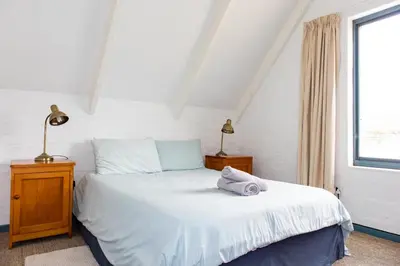 a bedroom with a white bed and a window at Bagatelle in Pringle Bay